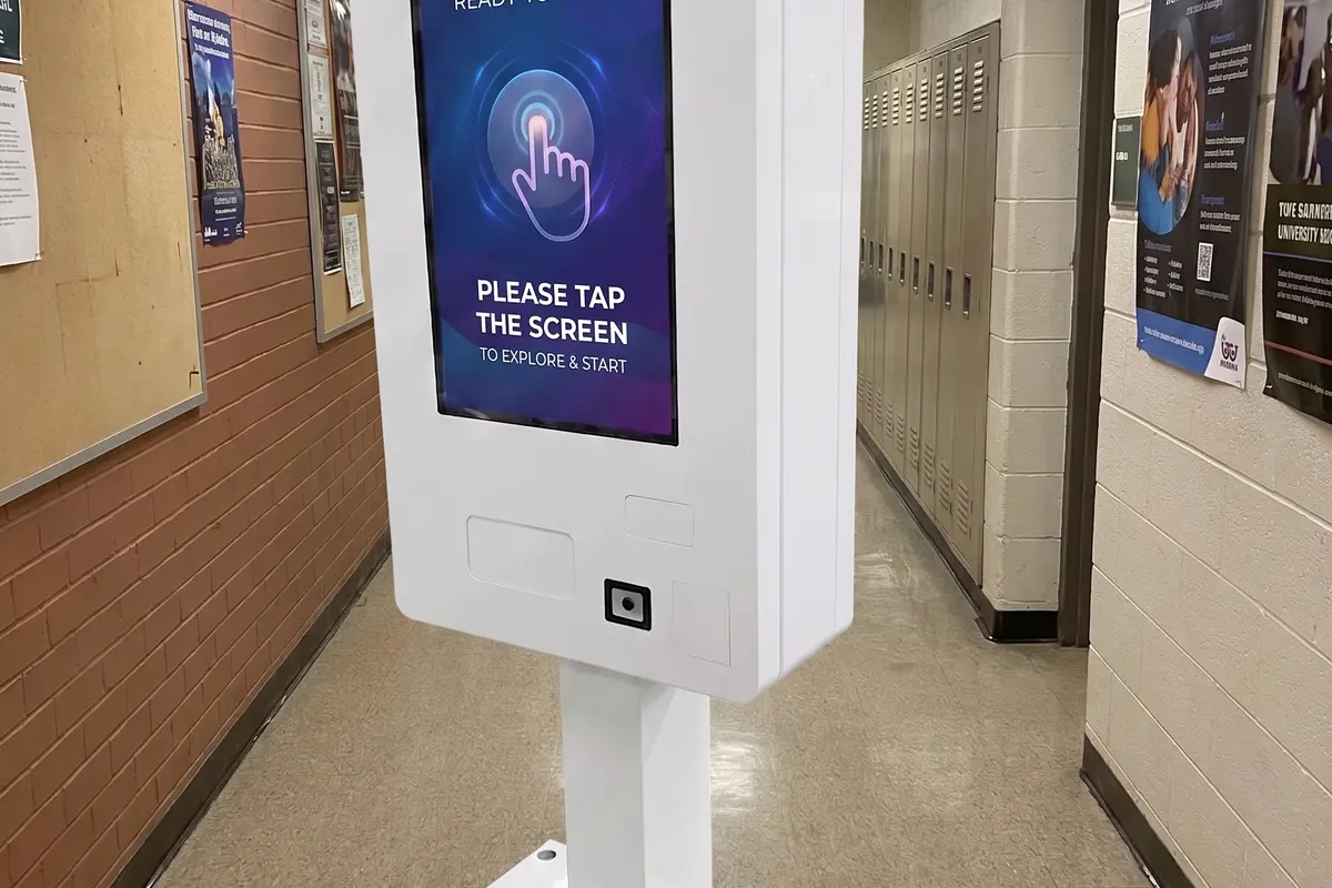 Smart vending machine in a student hallway with lockers and campus notices