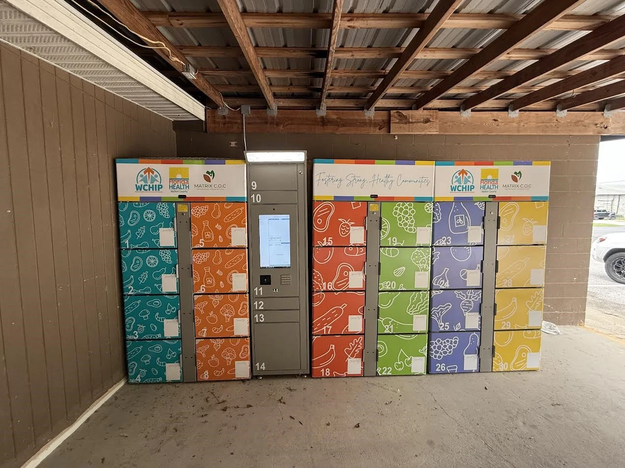 Colorful refrigerated food pantry lockers installed under an awning